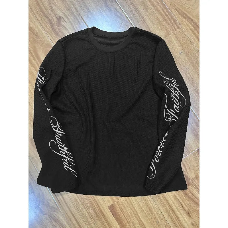 This Is A Black Waffle Patterned Long Sleeved Top with A Loose Street Style and Printed Sleeves.